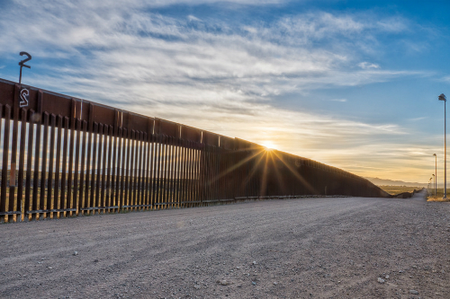 Fence at US-Mexico border representing Trump immigration policy