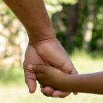 Father and son holding hands representing family green cards for members of lawful permanent residents for Shaftel Law